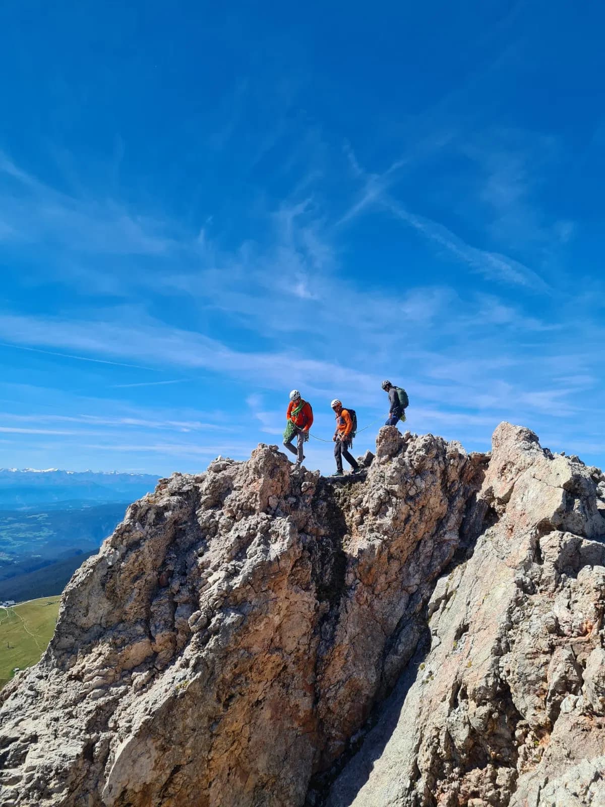 Eine Gruppe mit Bergführer auf einem Felsgrat in der Nähe des Gipfel des Langkofels