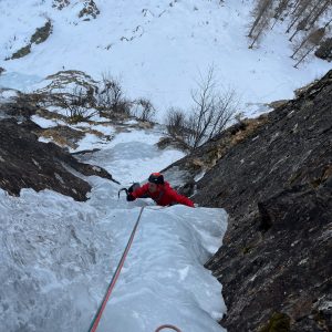 Eis in einer Rinne. Kletterer im Eis
